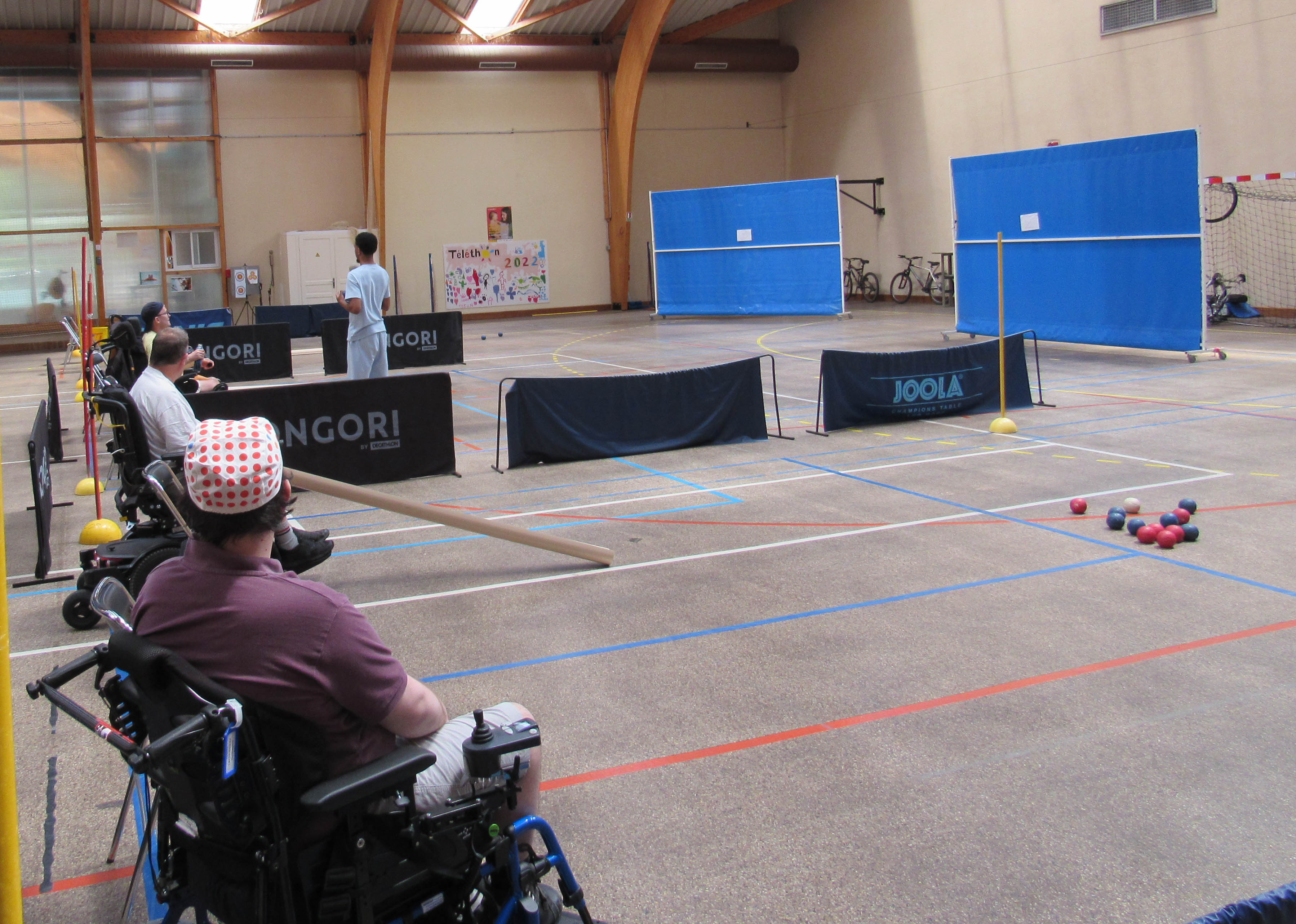 Tournoi de Boccia au gymnase du COS CRPF personnes en chaise lançant des balles dans un gymnase