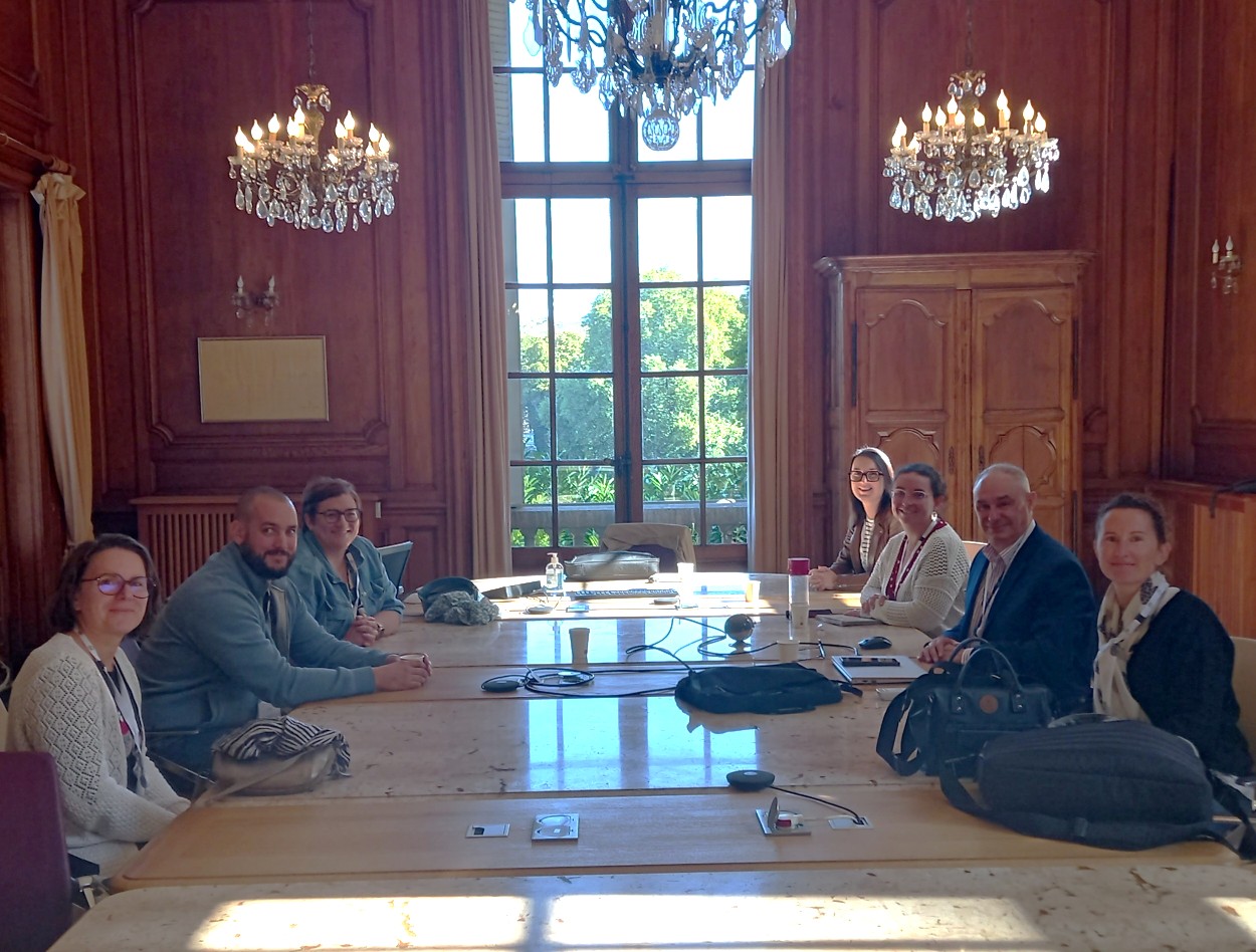 Plusieurs personnes autour d'une table regardant l'objectif