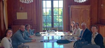Plusieurs personnes autour d'une table regardant l'objectif