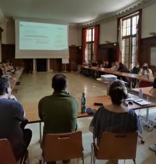 personnes autour d'une table avec écran et visio conférence