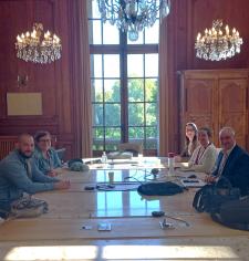 Plusieurs personnes autour d'une table regardant l'objectif
